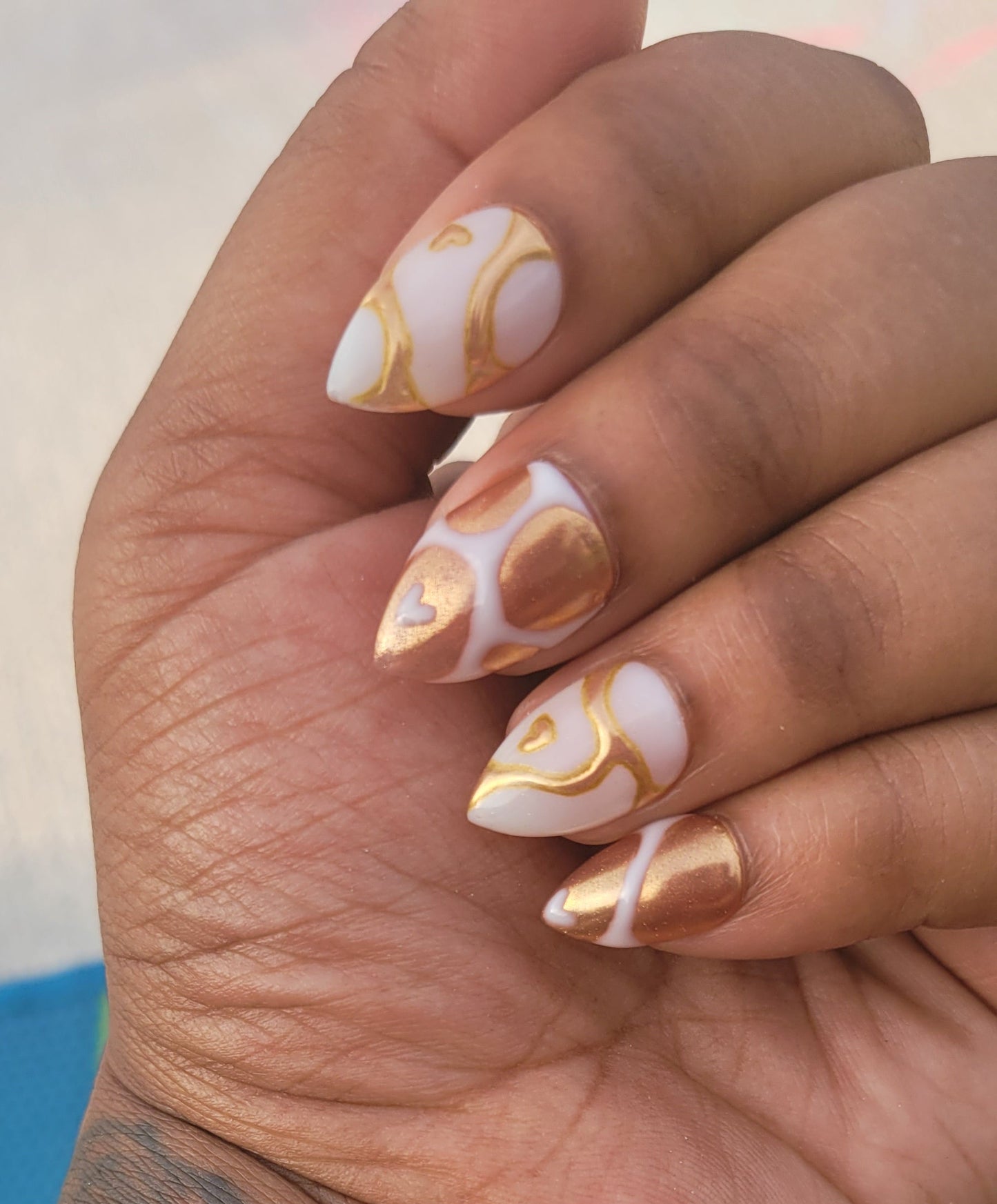 Hand with decorative nail art and tattoo on a blurred background