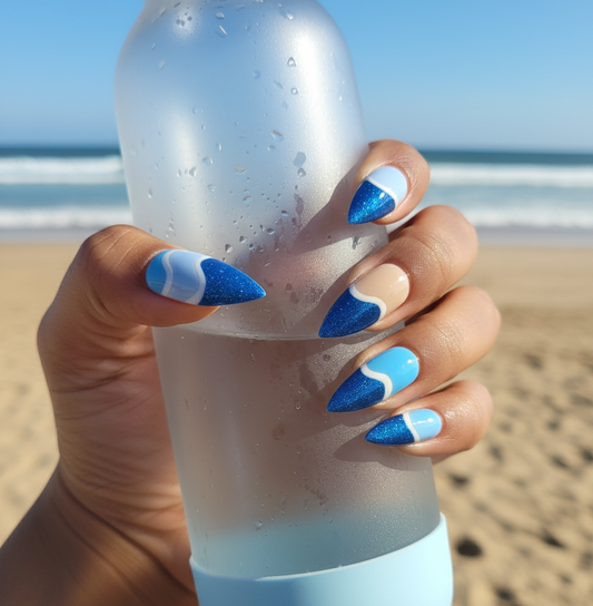Hand holding a white and blue tumbler with beach in the background